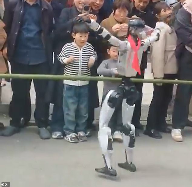 As the bot gets closer, a young boy can be seen drawing his arms in, in the hopes of avoiding its flailing metal limbs