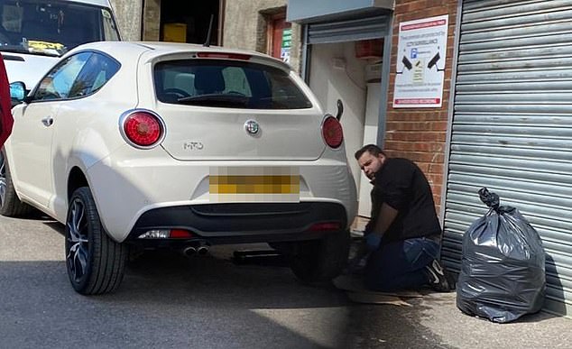 Massimo Palmieri seen kneeling beside a car in the lane that led to the legal dispute