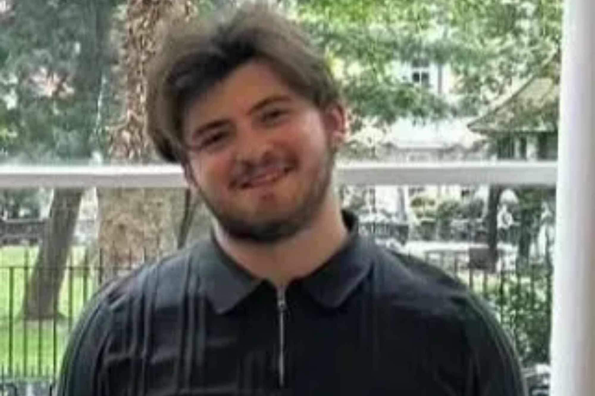 An image collage containing 1 images, Image 1 shows A man with dark hair and a beard, wearing a black long-sleeved shirt and black jeans, smiling with his hands in his pockets