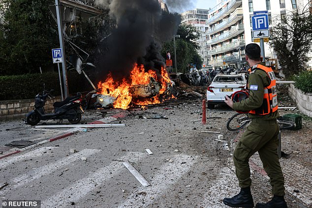 Fires rage after an Iranian ballistic missile smashed into Tel Aviv yesterday after evading Israel’s defences