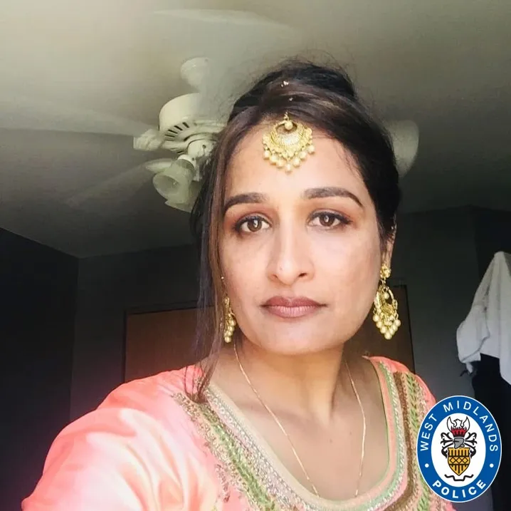 Image of a woman with long dark hair, wearing a pink top and gold earrings and head jewelry.