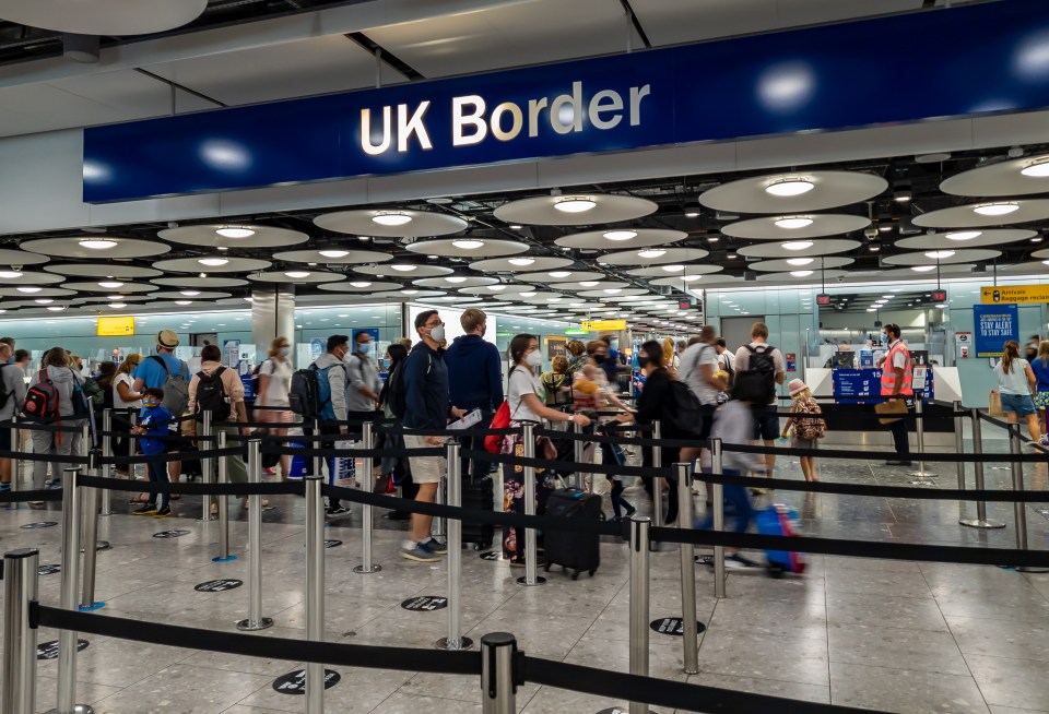Passengers waiting in line at UK Borders in Heathrow Airport Terminal 5 for immigration and passport control.