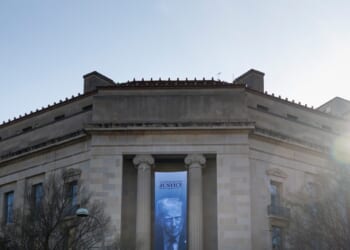 A banner of President Donald Trump hangs outside the U.S. Department of Justice on Saturday, March 21, 2026, in Washington, D.C.