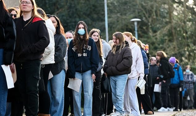 People, mainly students, queue to receive Meningitis B vaccinations at a sports centre on the University of Kent campus