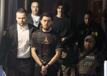 Ibrahim Kayumi (front) and Emir Balat (back) in federal custody leaving the NYPD's 26th Precinct stationhouse in Manhattan on Monday