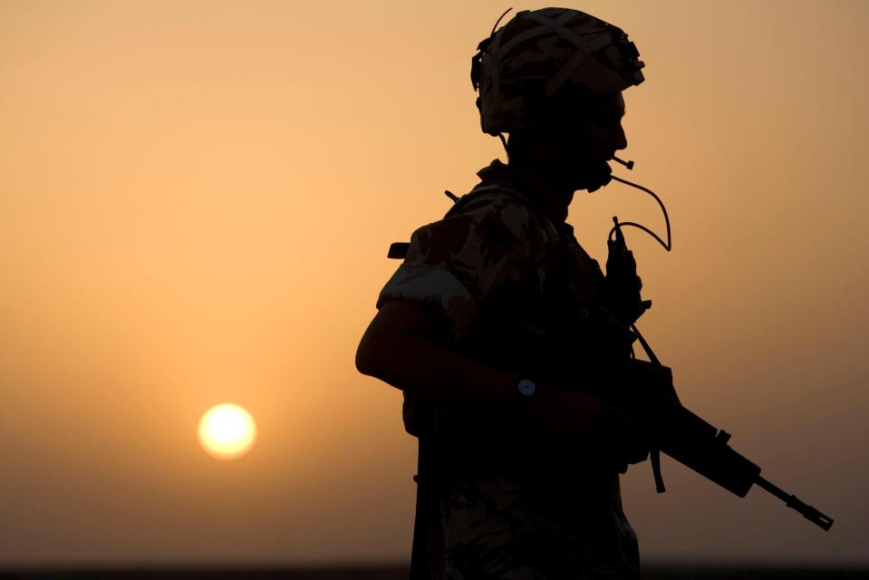 A soldier from the 1st Battalion Devonshire and Dorset Light Infantry, silhouetted against a setting sun in Iraq.
