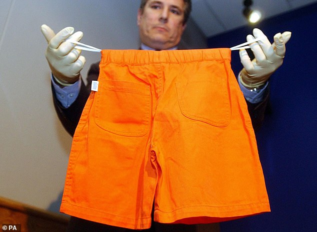 A police officer shows a pair of shorts found on Adam when his torso was discovered in 2001
