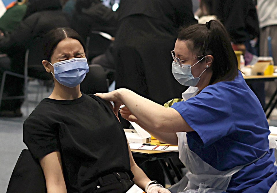 A student grimaces while receiving a Meningitis B vaccine at the University of Kent.