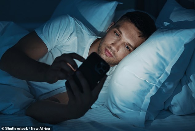 Blue light in phone screens has been shown to suppress the production of melatonin (stock image)
