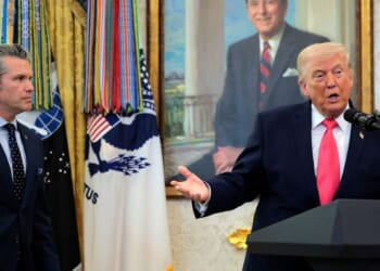 President Donald Trump takes questions as Secretary of War Pete Hegseth looks on during a ceremony for newly sworn in Secretary of the Department of Homeland Security Markwayne Mullin in the Oval Office at the White House on March 24, 2026, in Washington, D.C.