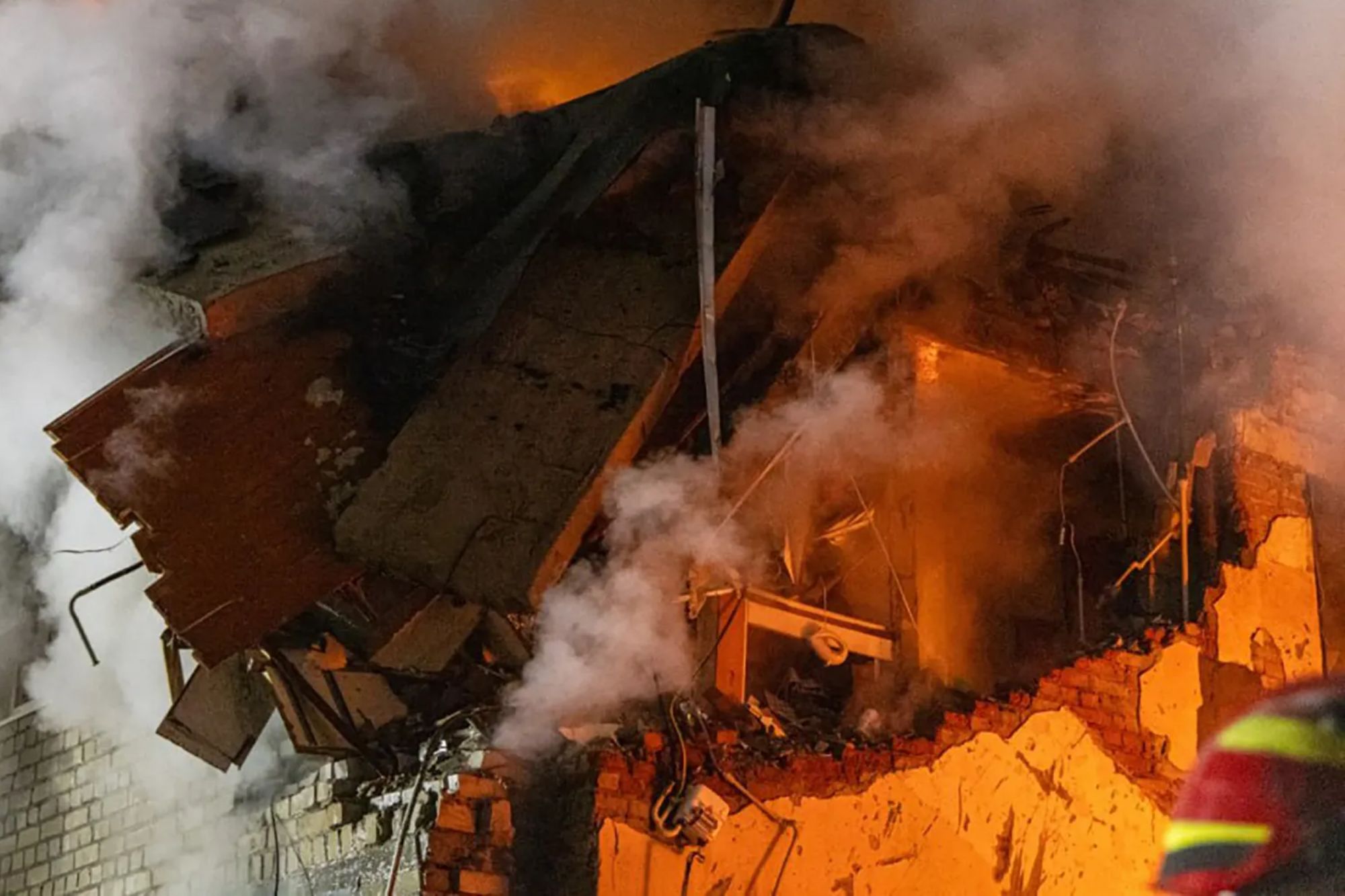 An image collage containing 1 images, Image 1 shows The remains of an apartment building in Kharkiv on fire and smoking after a deadly Russian strike