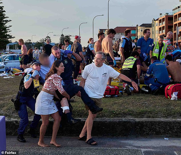 The pair (front row, white T-shirt and red-and-white top) were among the first responders to the Bondi terrorist attack