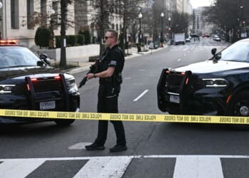 A member of the U.S. Secret Service patrols the scene where a van plowed into barricades near the White House in Washington, DC on March 11, 2026.
