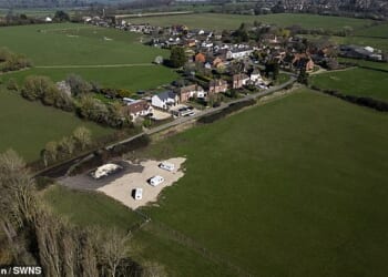 Many of the 800 residents of Dinton, near Aylesbury, Buckinghamshire, fear they have fallen victim to a 'land grab scam' over a tennis-court sized plot of land on a greenfield site (pictured) on the outskirts of their village