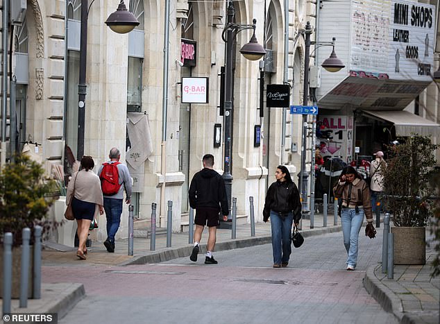 People walk in the coastal city of Limassol, Cyprus, March 24