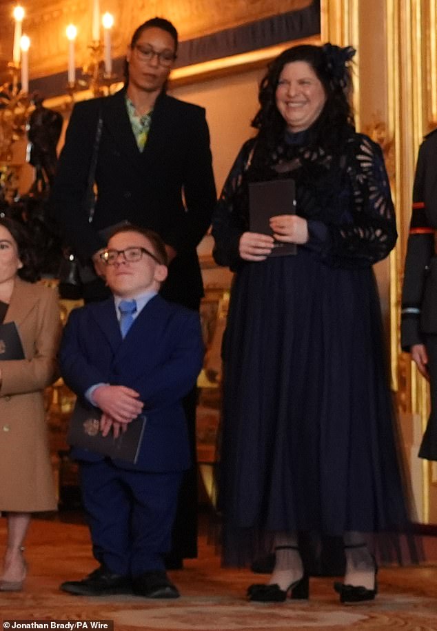 The woman Warwick affectionately calls 'Sponge' was also alongside his two children this week at Windsor Castle as the actor accepted an OBE from the Prince of Wales