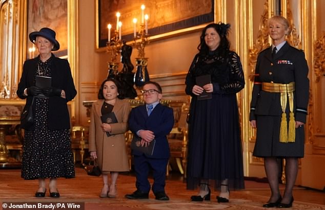 The Harry Potter star was joined by the mystery companion (seen second right), his daughter Annabelle and son Harrison as he was made an Officer of the Order of the British Empire (OBE)