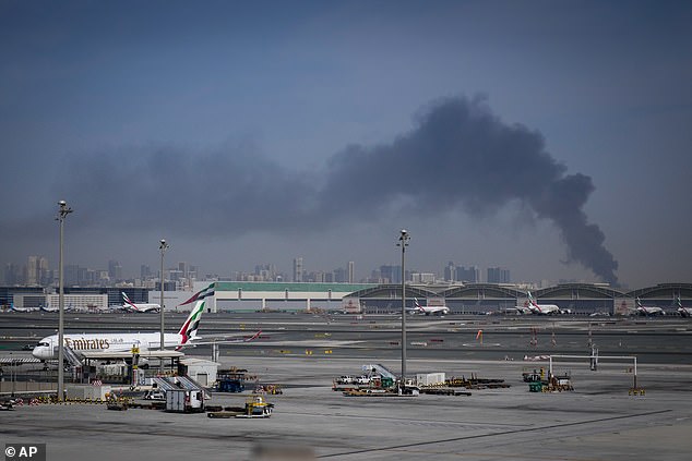 Smoke rises from Dubai International Airport this morning as Emirates planes remain grounded