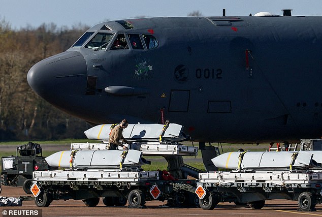 A member of a ground crew works to load cruise missiles into a US Air Force Boeing B-52 Stratofortress at RAF Fairford airbase, used by United States Air Force