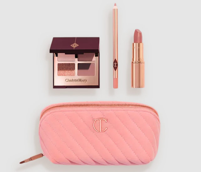 Charlotte Tilbury makeup set including an eyeshadow palette, lip pencil, lipstick, and a pink quilted makeup bag.