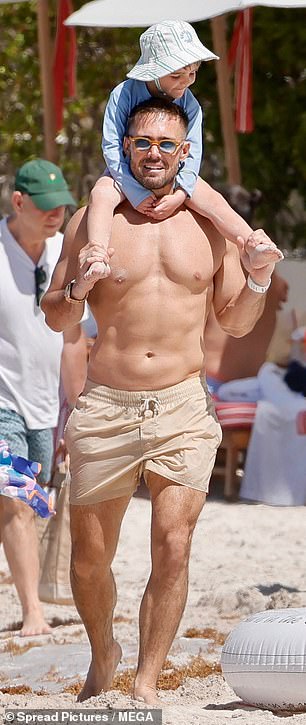 Spencer kept a tight grip on his son's ankles while walking him across the sand