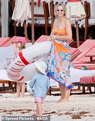 The TV presenter carried an inflatable ring as she prepared to wade out into the water with her children on Tuesday