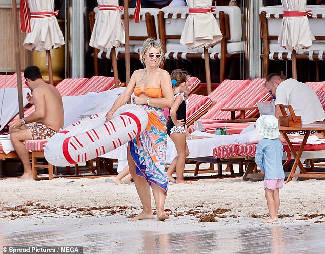 Mother and son were seen idling by the shoreline as fellow holidaymakers relaxed on their sunloungers