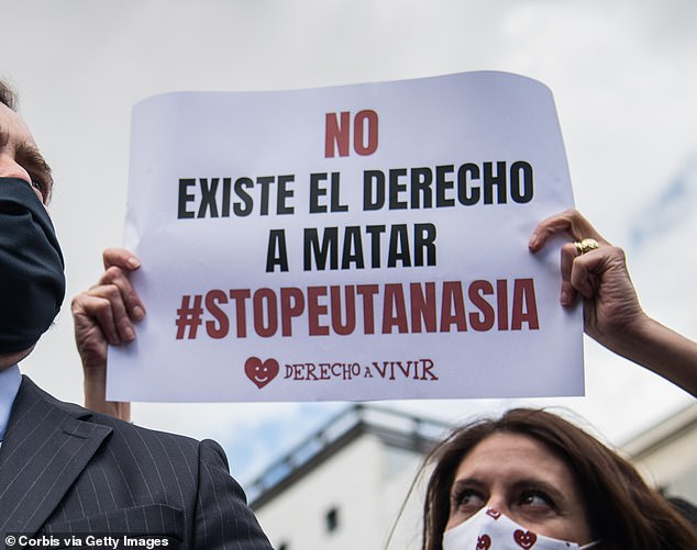 A protester pictured with a sign reading: 'The right to kill does not exist. #StopEuthanasia'