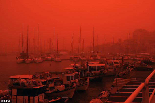 Boats in the Old Venetian harbour of Heraklion sit under an eerie red sky on the Greek island
