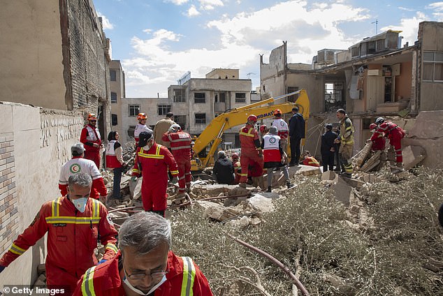 Iranian Red Crescent workers gather near an apartment hit by an airstrike on Monday in Tehran, Iran