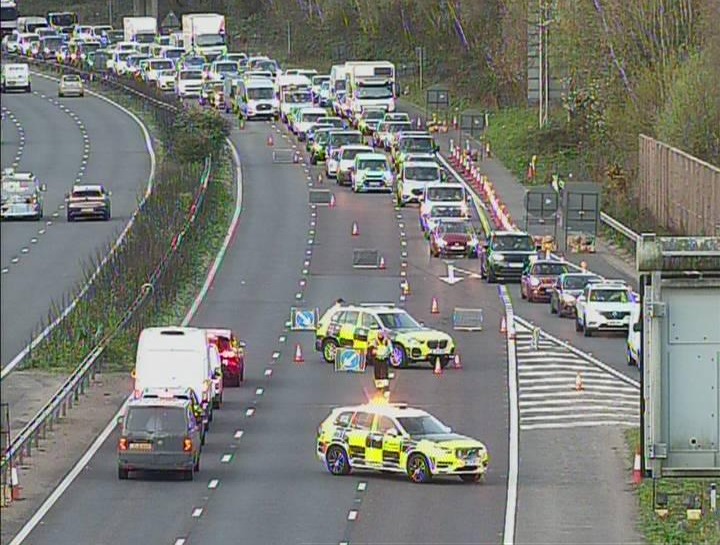 Traffic congestion on a highway due to roadwork or an incident, with emergency vehicles present.