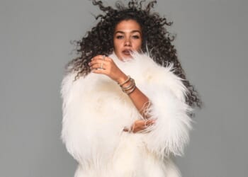 Olivia Dean shows off her endless legs as she poses in just a fluffy white coat after awards season success