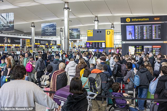 Passengers queue for baggage check at Heathrow Airport Terminal 2 in west London on Thursday as millions of journeys are expected to take place across the UK during the bank holiday weekend