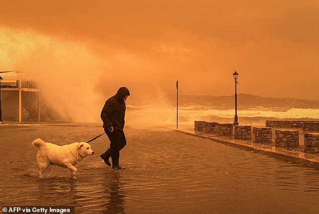 A local resident walks on the port of Ierapetra during a dust storm on the Greek island of Crete on April 1, 2026