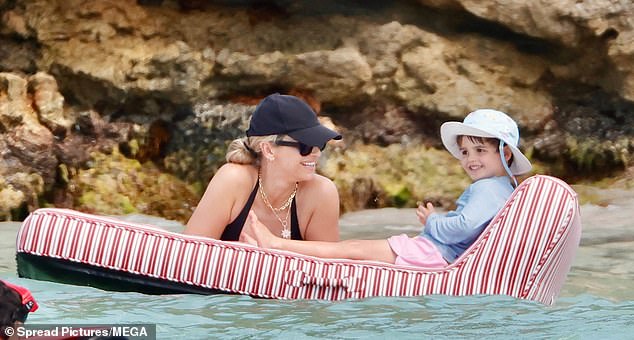 The devoted parents played with their children in the water as they floated on lilos