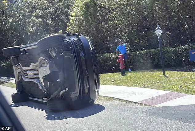 The golf icon was pictured standing by his overturned vehicle after the high-speed crash