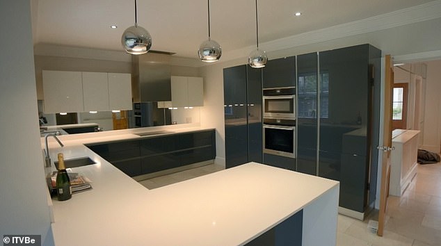 The airy kitchen featured grey floor-length cupboards and a spotless white countertop
