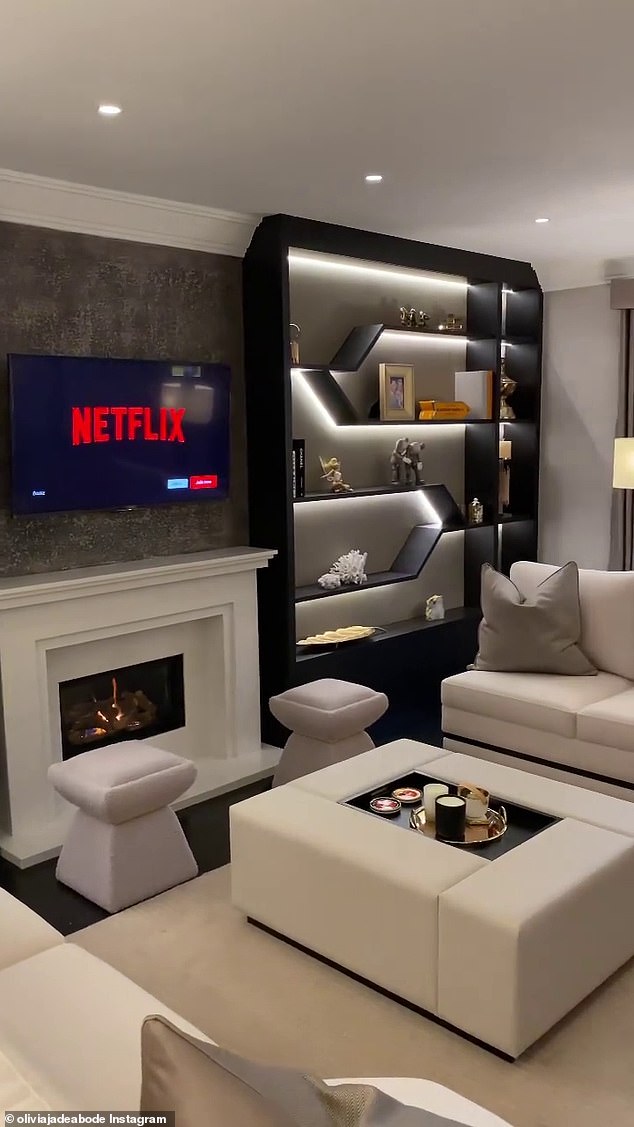 A view of the living room, with beige leather furniture and a fireplace