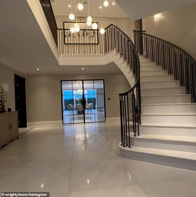 A view of the hallway with a grand staircase