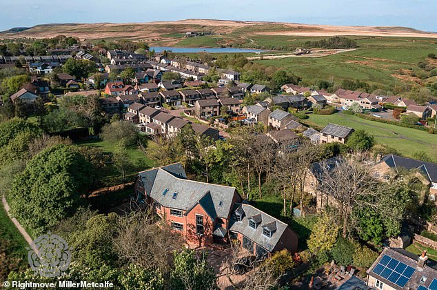 The property has six bedrooms and boasts 'dramatic' floor to ceiling windows and a large kitchen diner