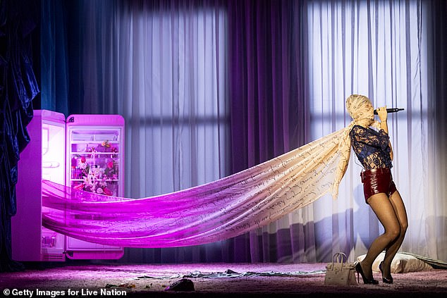 At one point, she strolled over to a fridge on stage, pulling out a piece of fabric printed with handwritten lyrics, which she wrapped around her head while performing her track 4chan Stan