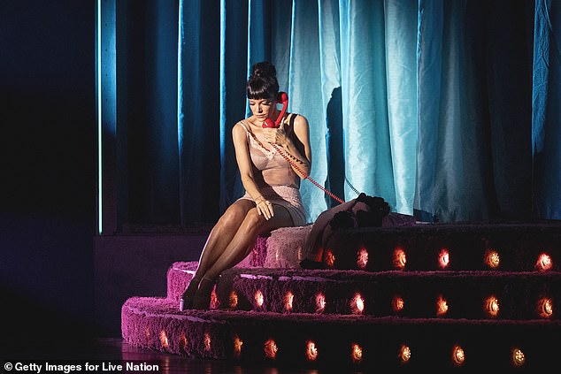 The star later removed her top to reveal a sheer nude cami with lace trim, flashing a glimpse of her bra