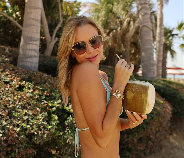 Shielding her eyes behind chic shades, Amanda sipped from a coconut while posing up a storm and topping up her tan on the beach