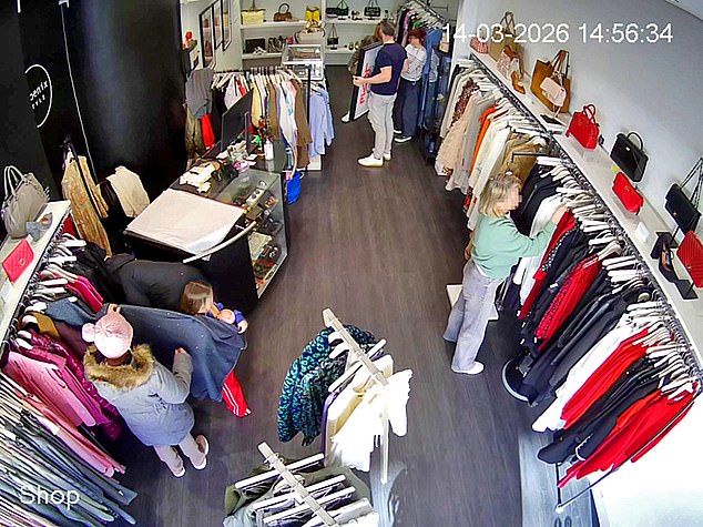 Another video (pictured) features two women and a child in Phoenix Style's Wimbledon branch last month. In a co-ordinated move, the little girl is seen pulling a dress from the rack and – while still clutching her doll – using it as a screen to conceal a blonde woman as she snatches two luxury handbags