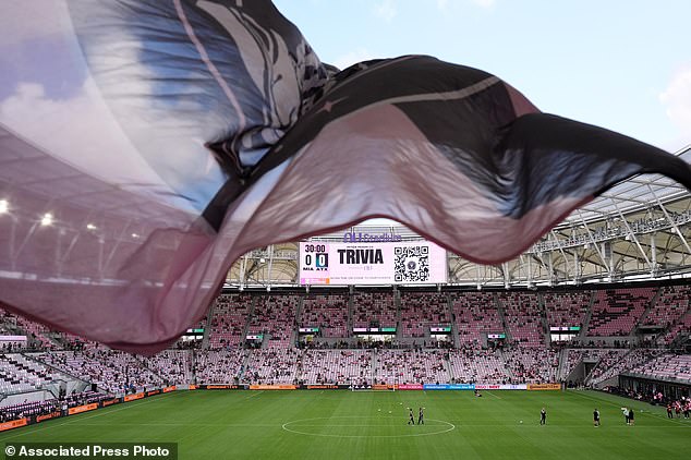 Inter Miami fans wave a flag in Nu Stadium ahead of the team's first MLS soccer match in their new stadium, against Austin FC, Saturday, April 4, 2026, in Miami. (AP Photo/Rebecca Blackwell)