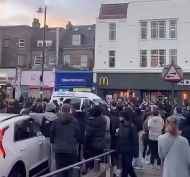 Police try to disperse the youths who took to the streets in Clapham on Tuesday afternoon