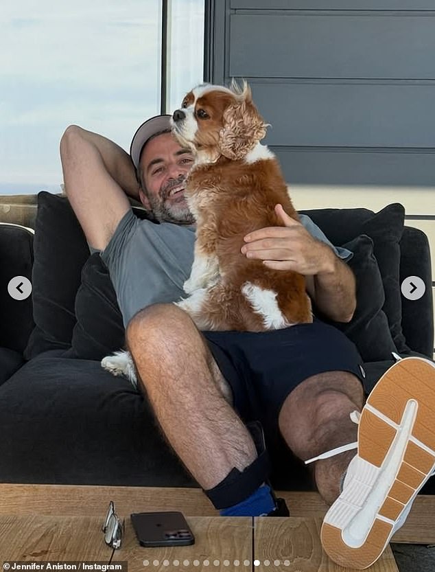 Curtis was featured in two photos in Aniston's latest post, including this one showing him curling up to an adorable dog