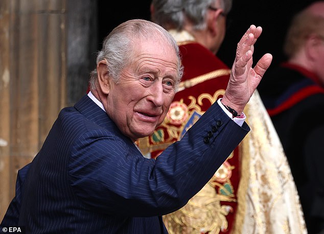 King Charles waves to onlookers patiently waiting for a glimpse of the royals as he arrives at the service