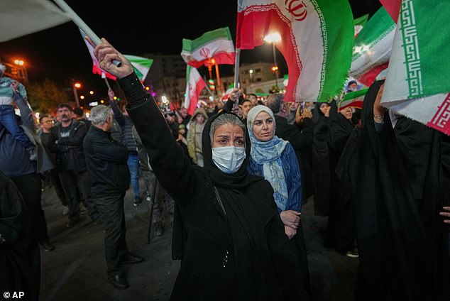 He said Iranians are afraid to take to the streets to protest the regime out of fear they would be shot. Women holding Iranian flags are seen at a pro-government gathering in Tehran on Sunday