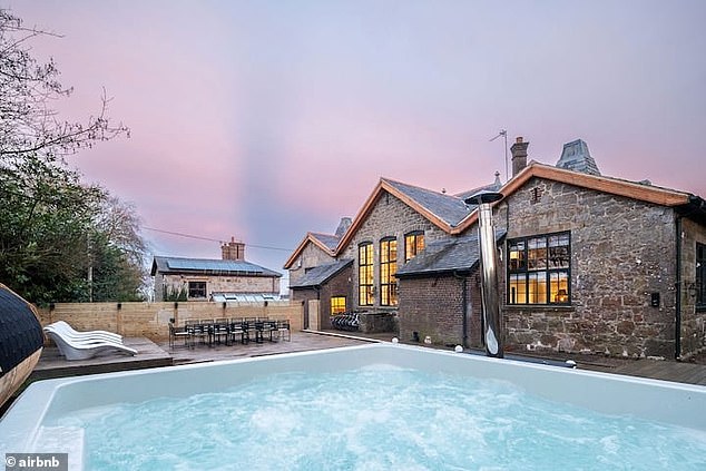 An outdoor hot tub is the focal point of the Airbnb's attractive back garden and patio